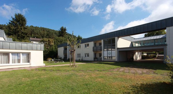 Blick auf ein modernes Gebäude mit vielen Fenstern vor einer grünen Wiese am Standort Rodalben